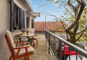 Make yourself comfortable for two in this compact vacation apartment with sea view. in Hreljin