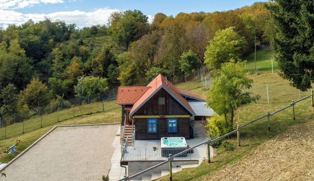 Forest home with jacuzzi, playground, and BBQ for family relaxation.