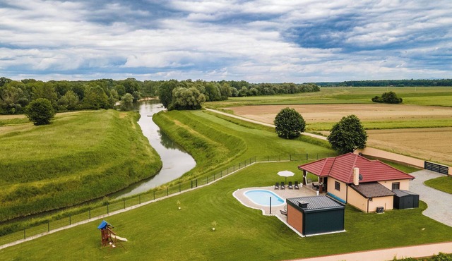 Riverside retreat with pool, summer kitchen, playground, and peaceful Drava views.